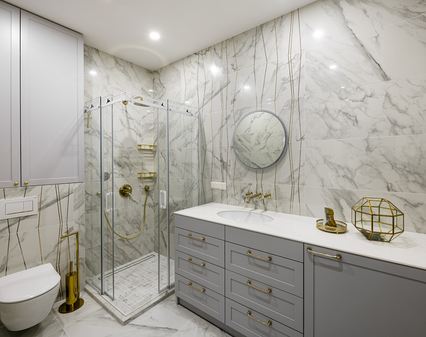 Shower enclosures and walls with gold-colour fittings